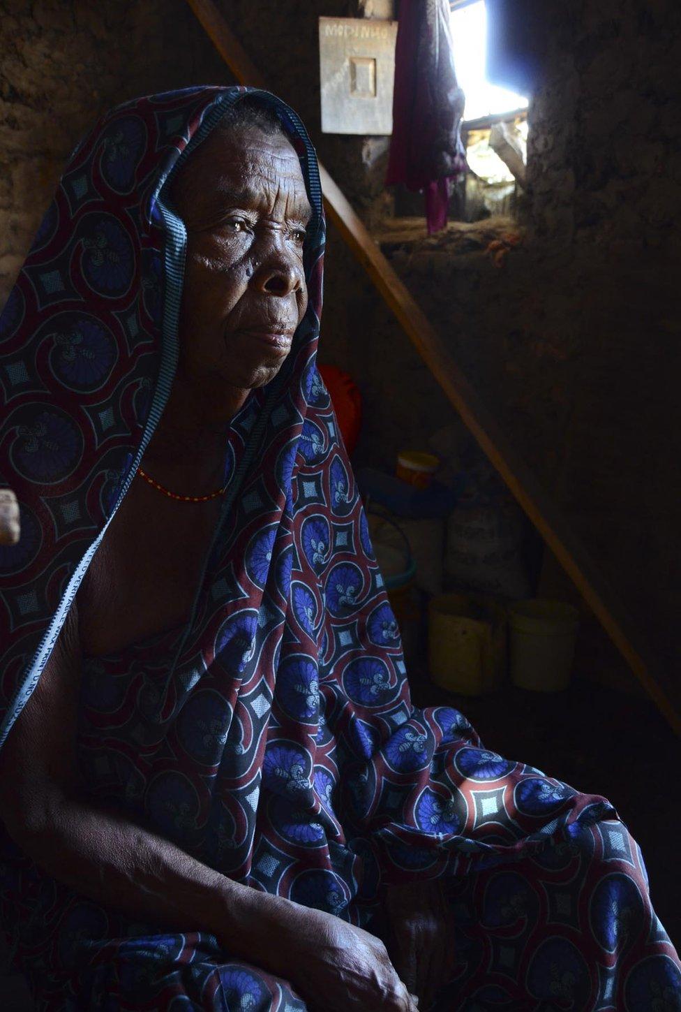 An elderly woman in a headscarf.