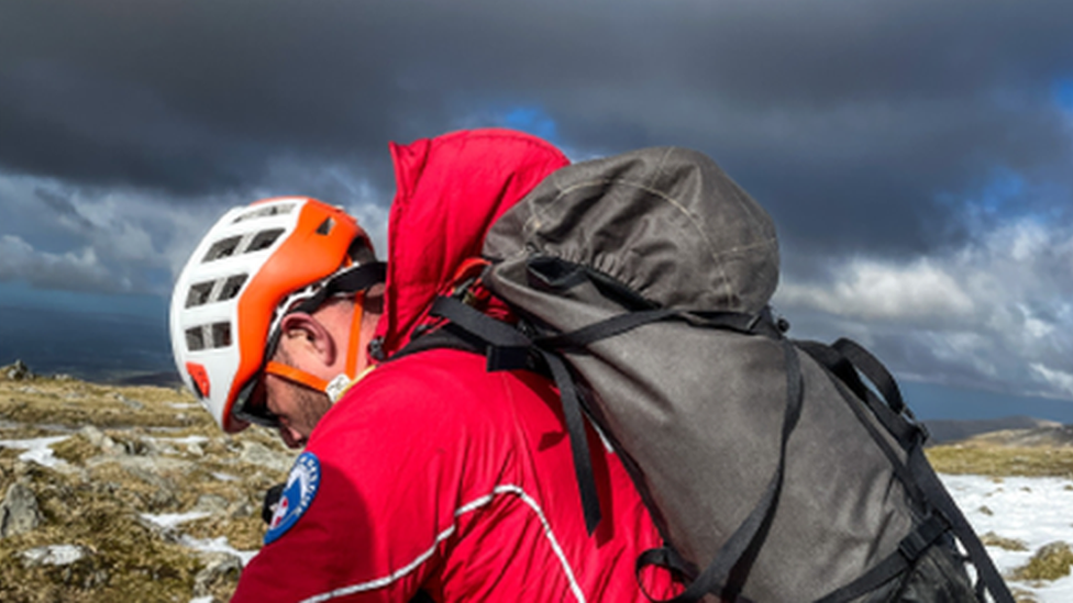 Rescuer with helicopter flying overhead