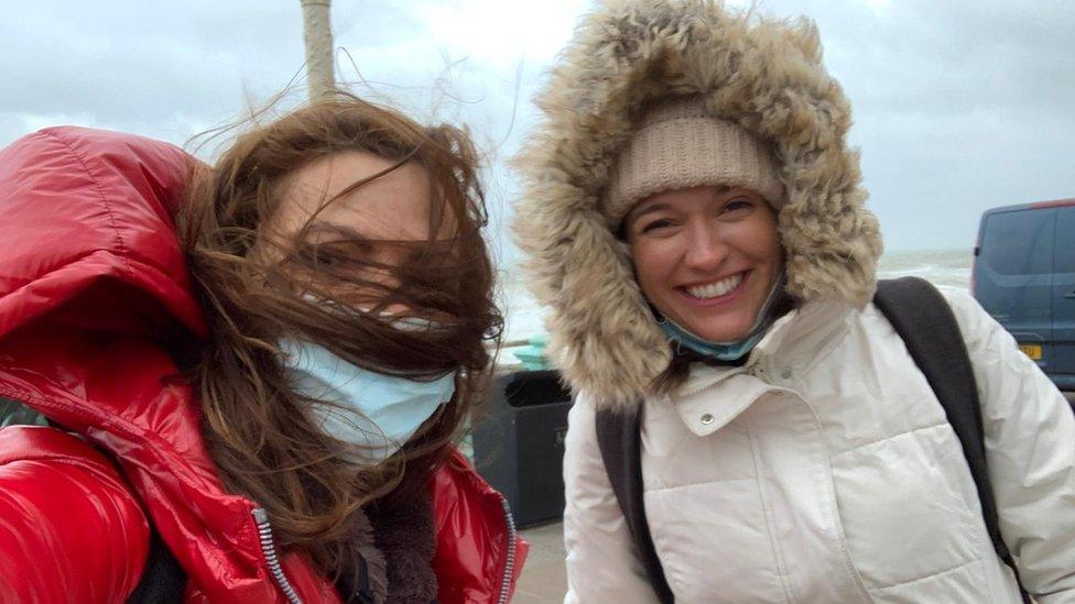 Katie with camerawoman Tracey Langford being blown about by the wind on the pier