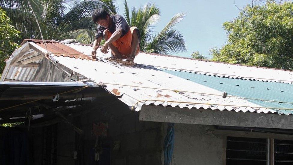 A resident secures the roof of his house in preparation for super typhoon Mangkut in Candon City, Ilocos Sur province, north of Manila on September 13, 2018