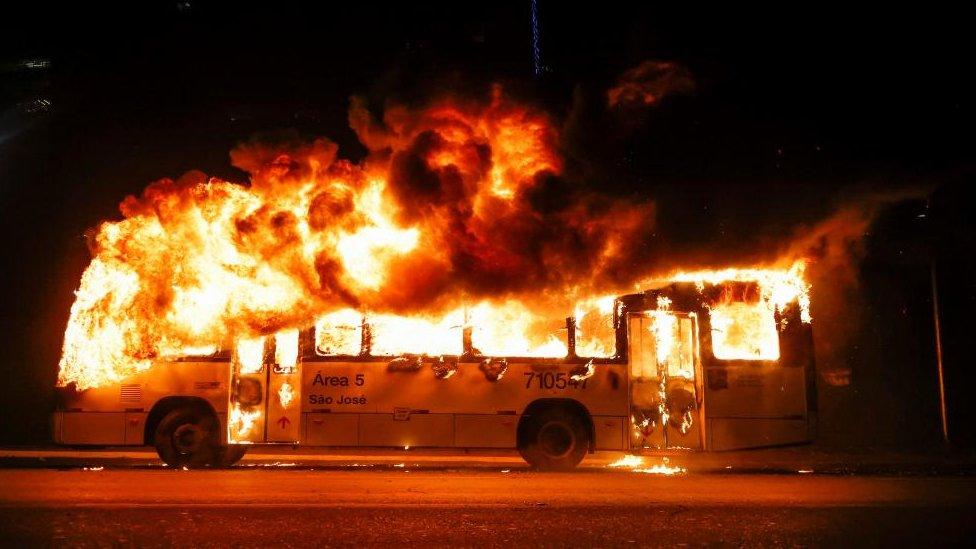 A bus is seen on fire as supporters of Brazil's President Jair Bolsonaro protest after supreme court justice Alexandre de Moraes ordered a temporary arrest warrant of indigenous leader Jose Acacio Serere Xavante for alleged anti-democratic acts, in Brasilia, Brazil, December 12, 2022.