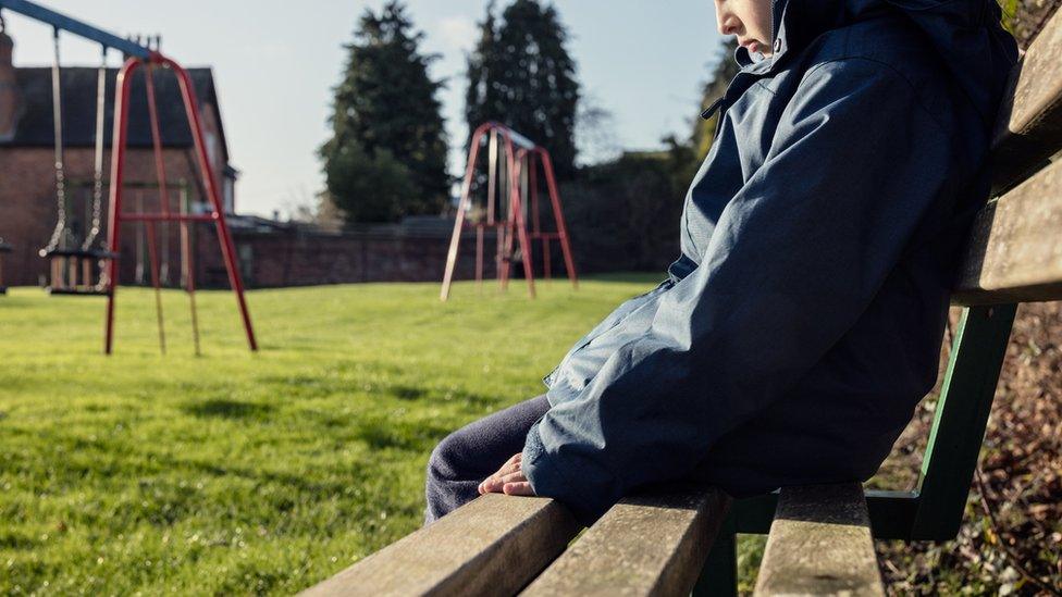 Sad child on a bench