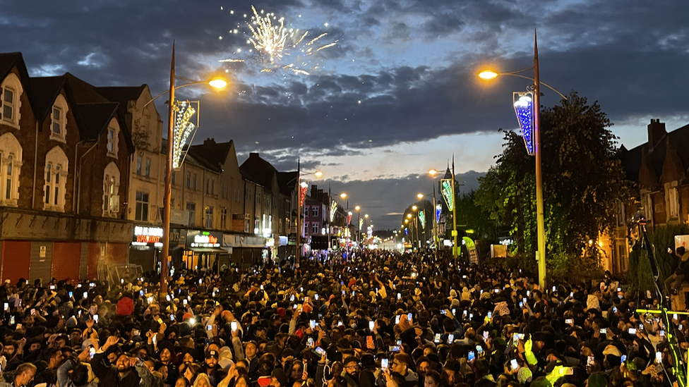 People watching a lights switch on