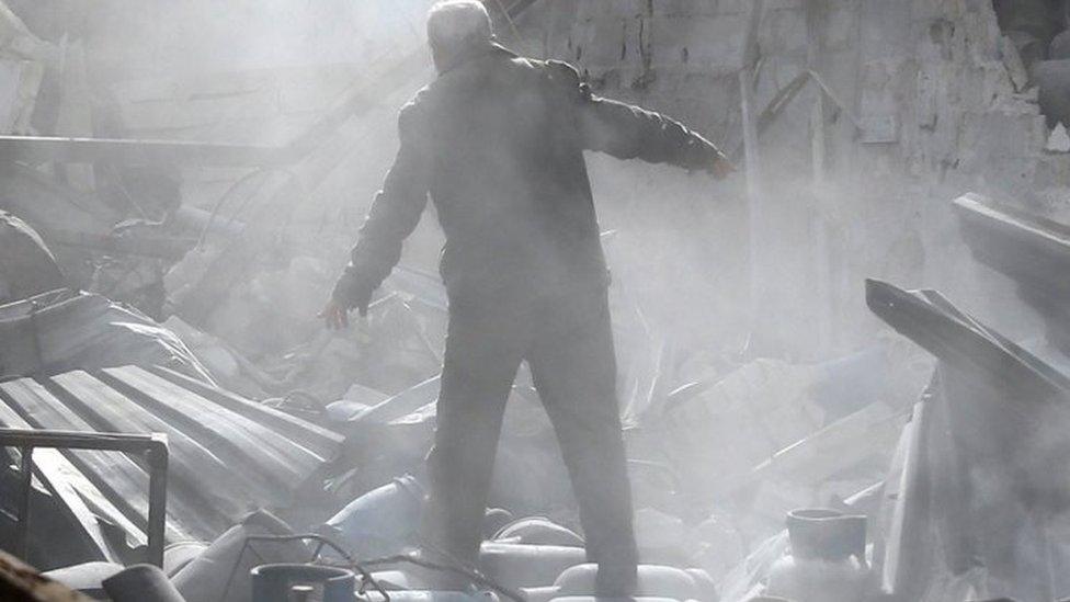 A man stands on the rubble of damaged buildings after an air strike on the rebel-held town of Mesraba in Eastern Ghouta, Syria. Photo: 26 November 2017