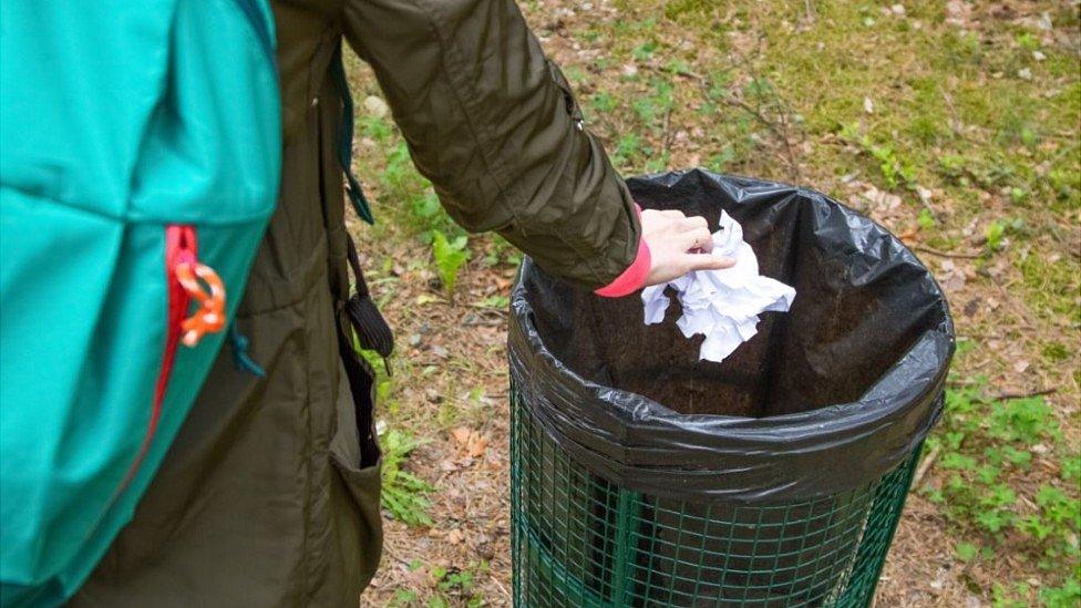 Person putting litter in bin