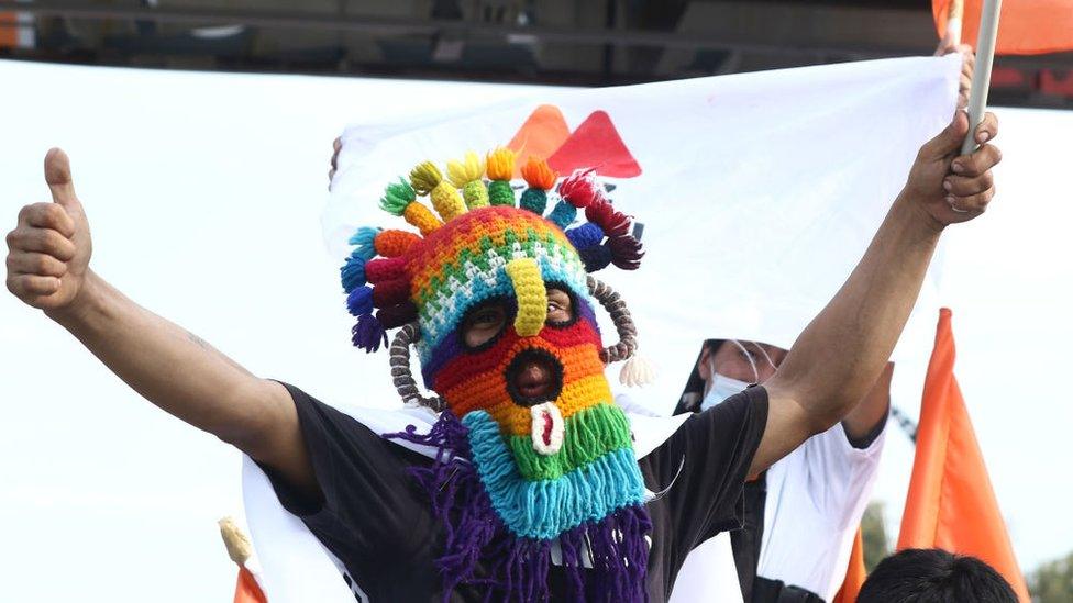 A supporter of Andrés Arauz wears a ski mask at a rally in Quito, 7 April