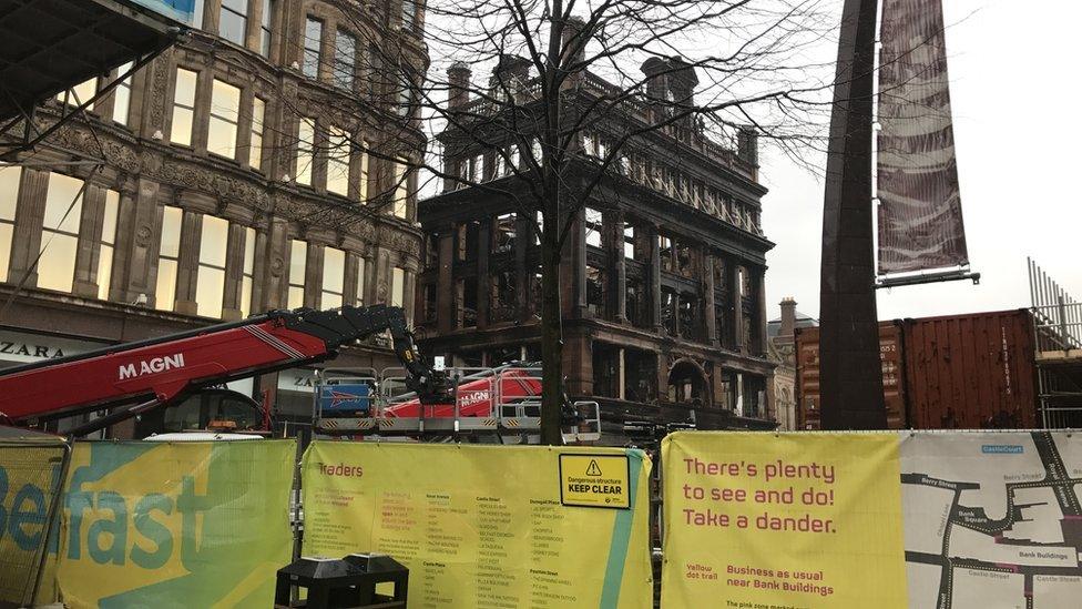 Shipping containers have been placed in front of the burnt-out building