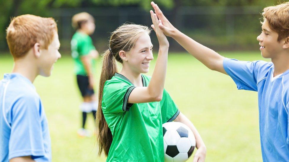 Boys and girls playing football