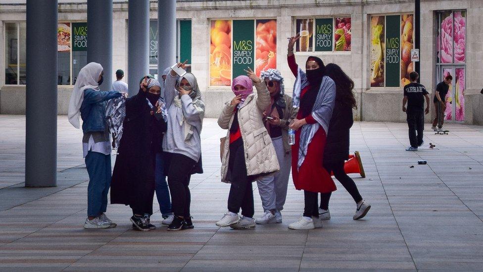 girls waving at camera