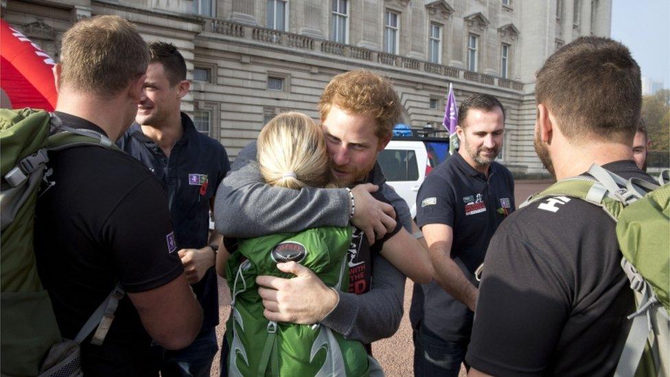 Prince Harry hugs a woman who completed the walk