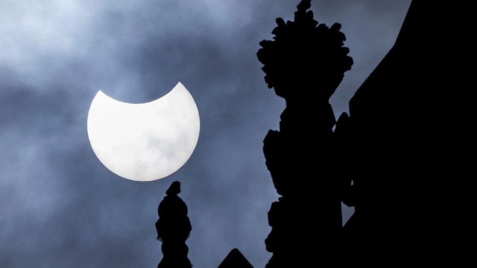 Partial solar eclipse is seen over the Houses of Parliament.