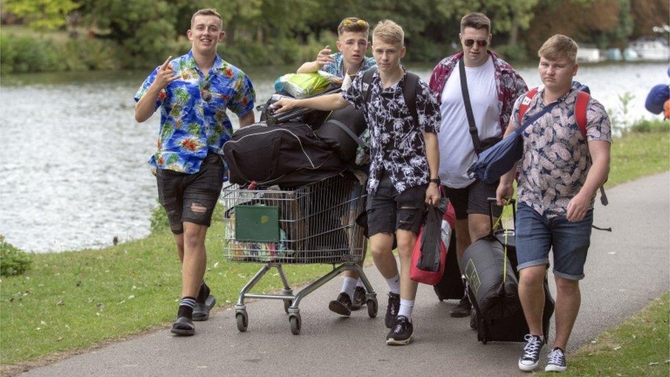 Young men with a trolley of camping kit