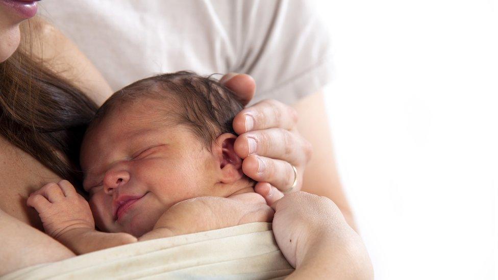 Newborn baby lying on mother's chest