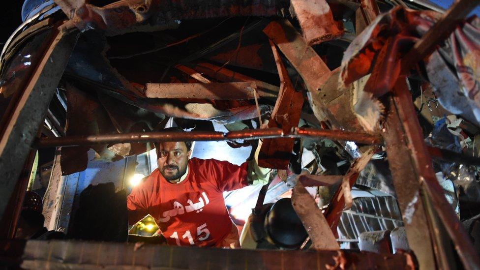 A Pakistani volunteer searches a damaged bus after a bomb explosion in Quetta (19 October 2015)