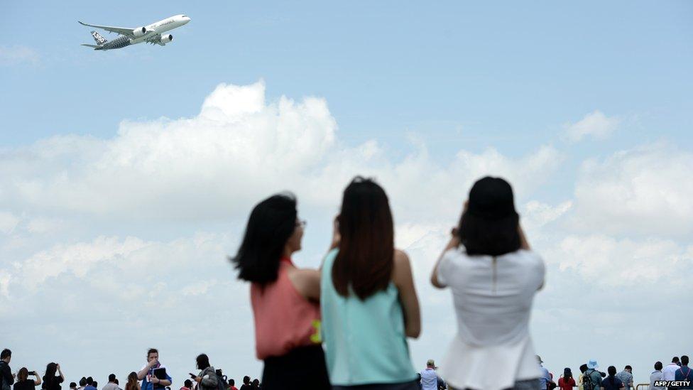 People watching an A350 fly by at the Singapore Airshow