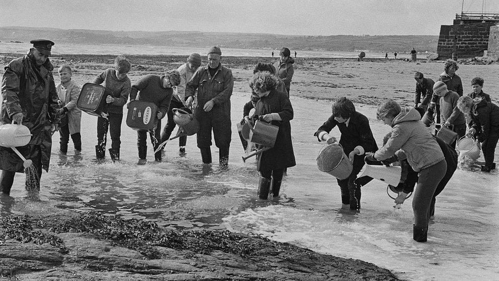 Volunteers try to disperse the oil