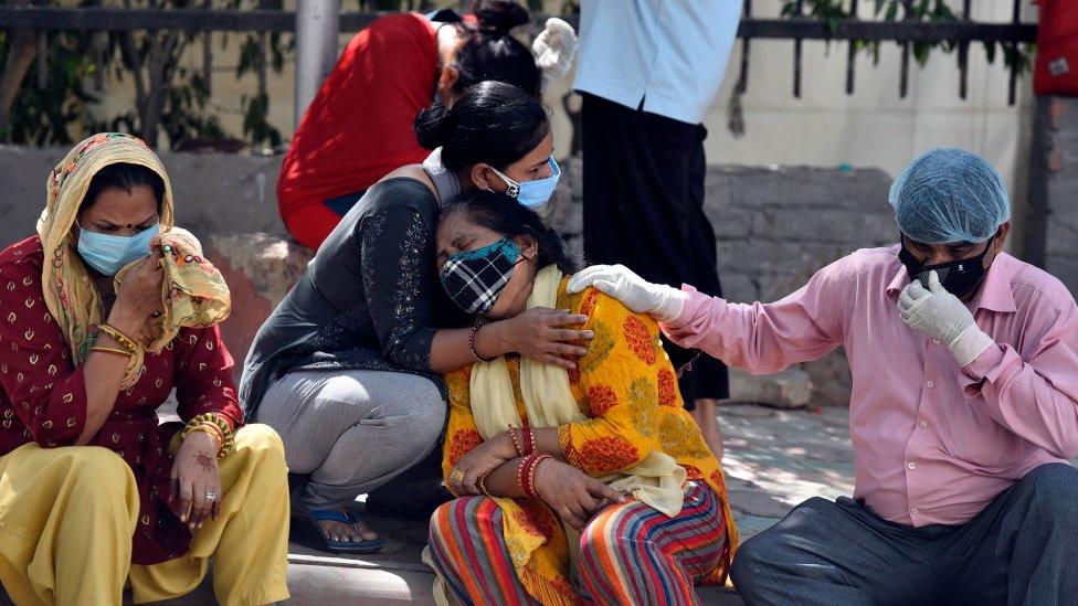 Grieving relatives and family members of Covid victims wait outside Maulana Azad Medical College mortuary to collect their bodies, on April 25, 2021 in New Delhi, India