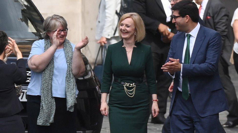 Liz Truss supporters greet her outside Parliament