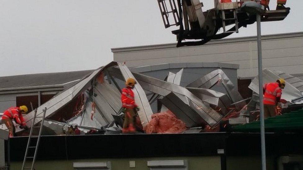 Firefighters on damaged roof
