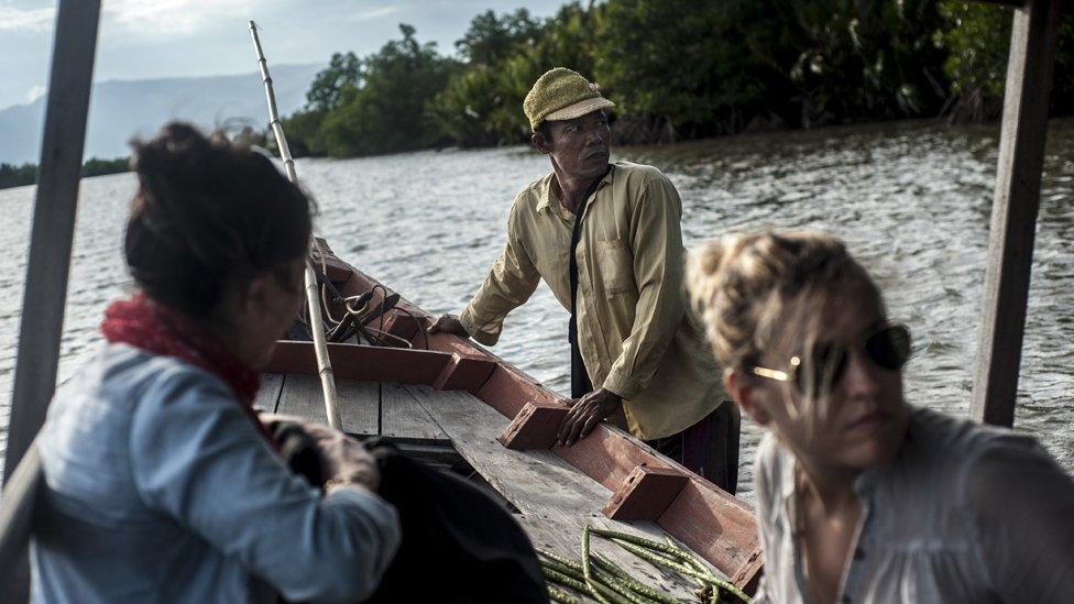 Tourists join Him Sim on a boat trip around the mangroves