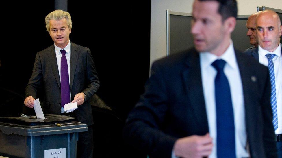 Bodyguards stand watch as firebrand Dutch lawmaker Geert Wilders, left, casts his vote in a non-binding referendum on the EU-Ukraine association agreement in The Hague, Netherlands, Wednesday, April 6, 2016.