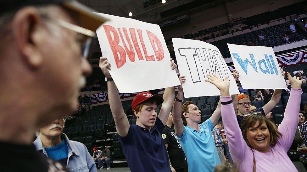 "Build the wall" signs at a trump rally