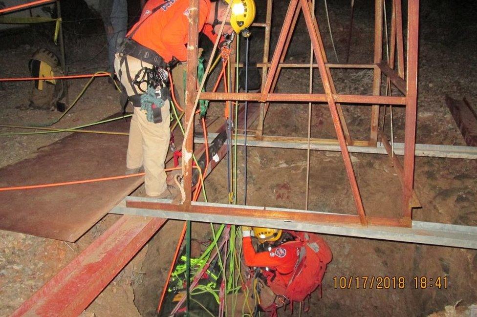 rescuers descend into the shaft