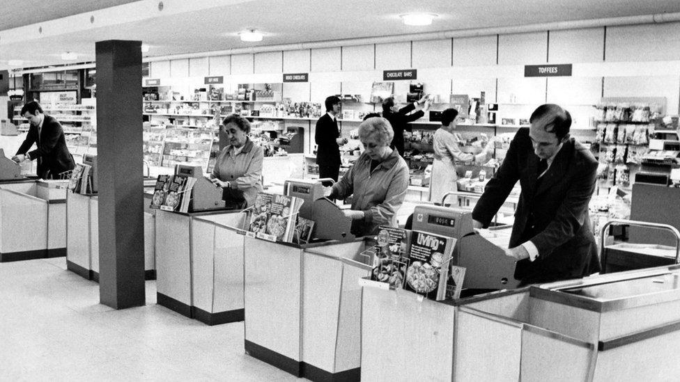 Four tills with clerks in the 1970s