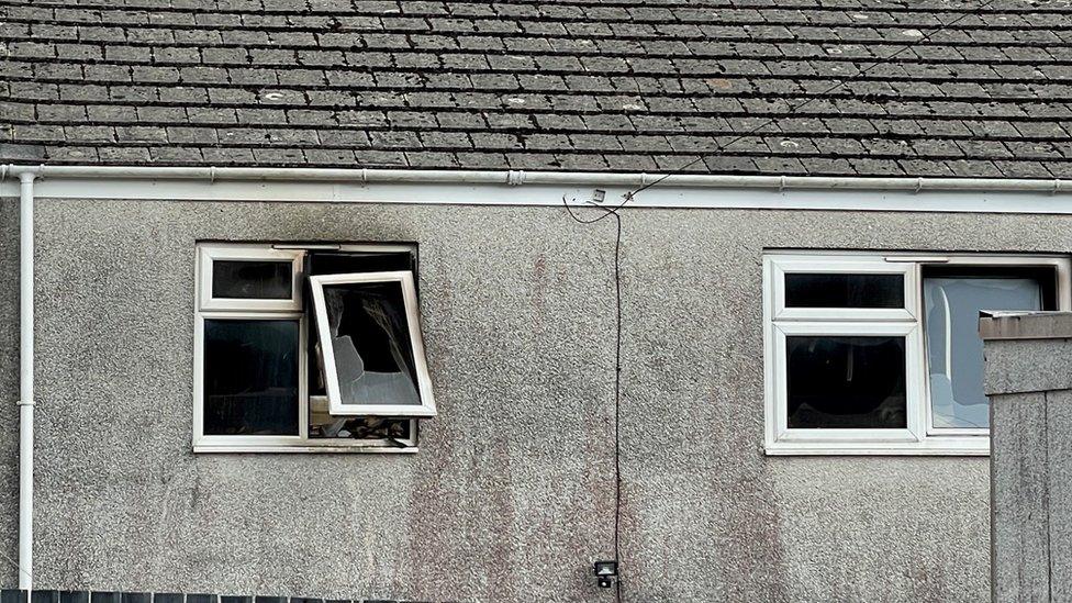 the burnt and damaged windows of the house