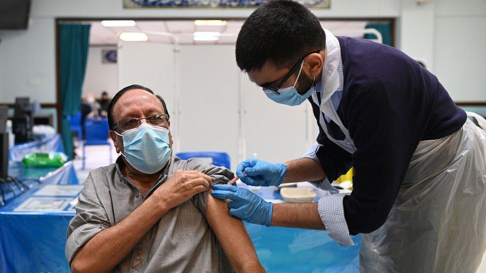 A pharmacist administers a Covid vaccine