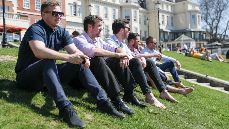 Men enjoy the sunshine on Richmond riverside in south-west London