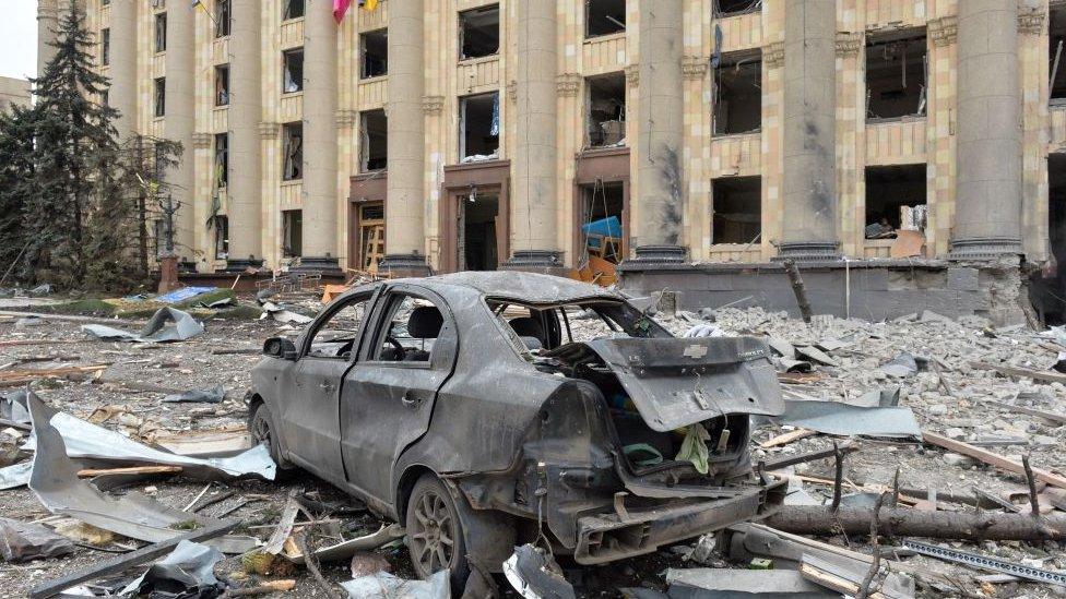 Destroyed car near building.