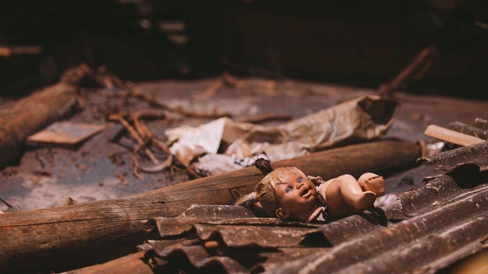 A doll is caked in mud in the rubble of Bento Rodrigues