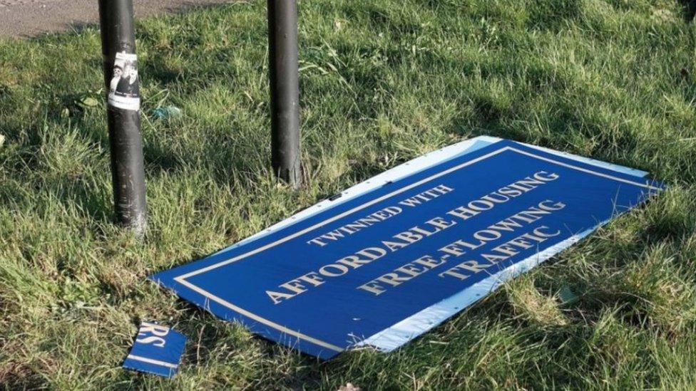 Oxford welcome sign broken on the ground