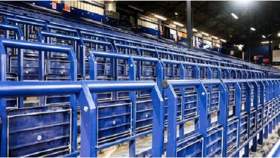 Blue seats and railings at a football stadium