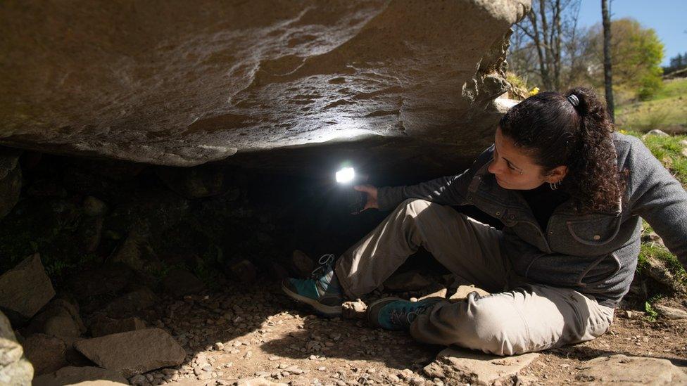 Dr Joana Valdez-Tullett, research assistant on Scotland's Rock Art Project, looks at the carvings