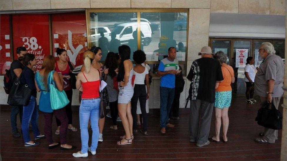 Cubans wait outside a movie theatre during the Havana Latin American Film Festival, on December 8, 2016.