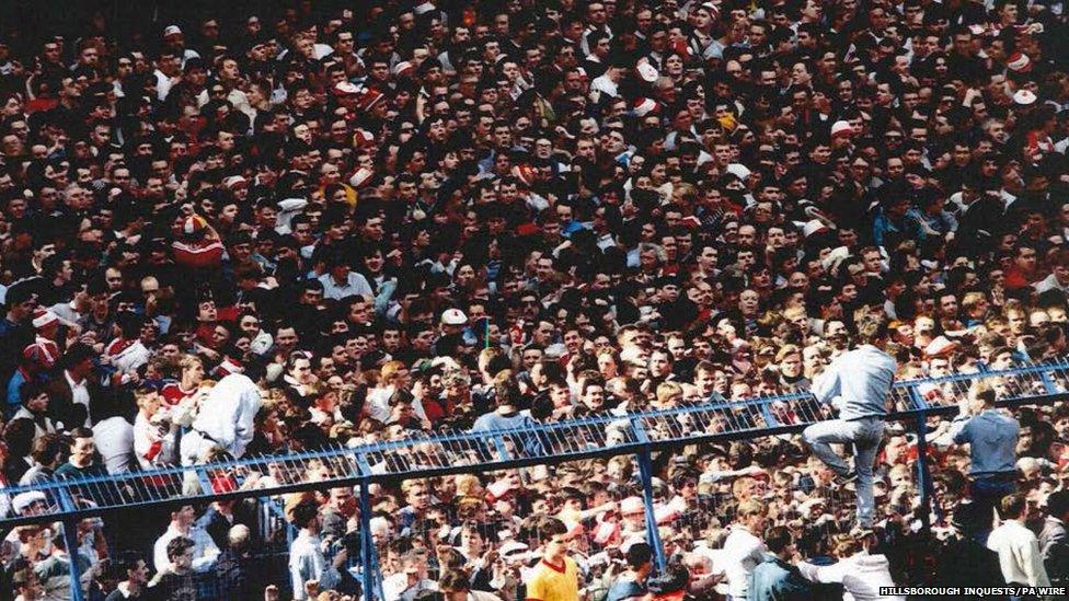 Fans attempt to escape the Leppings Lane end of the Hillsborough Stadium
