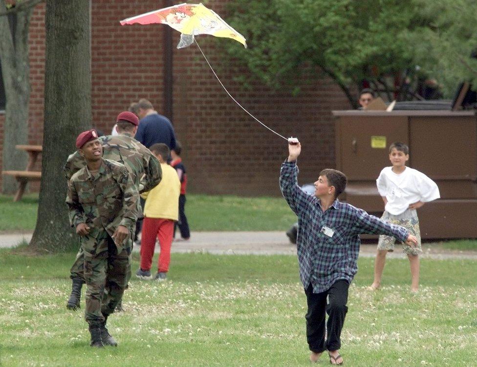 Boy flying a kite while running in a field