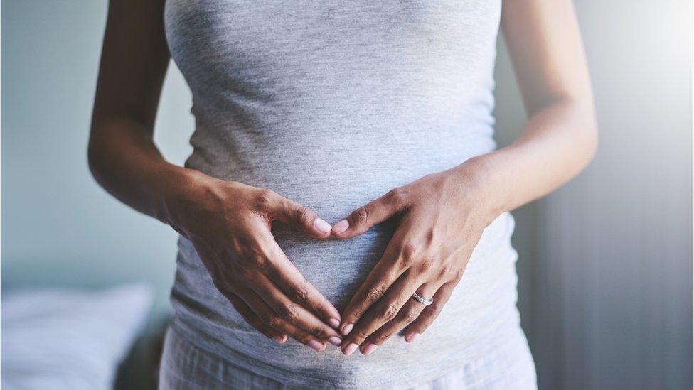 Pregnant woman holding her tummy