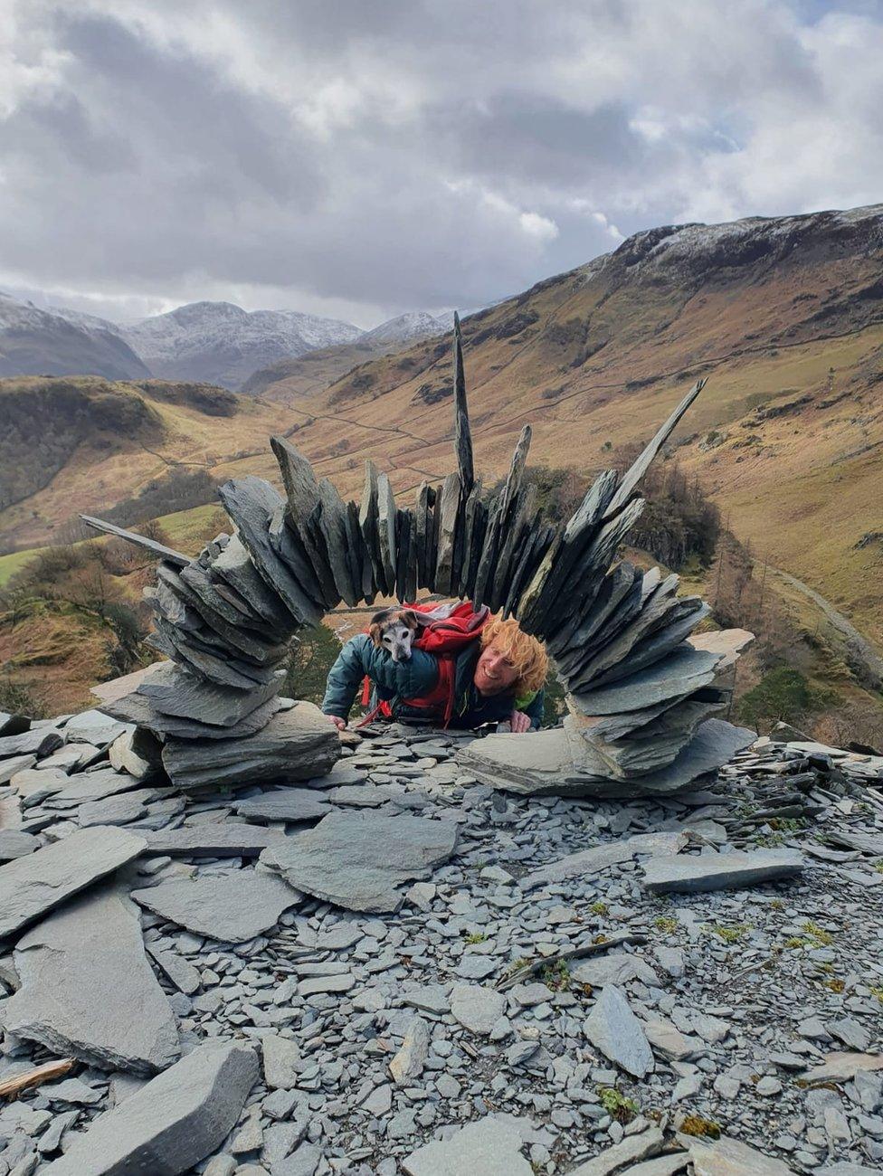 Rob Brown and his dog look through a slate arch