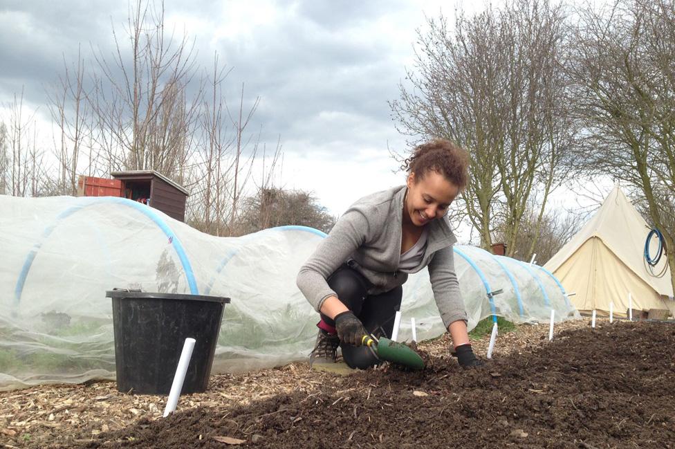 Sinead Fenton digs in the soil with a trowel