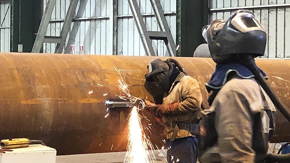 Factory workers weld pipes and girders in the Fensch valley region of France