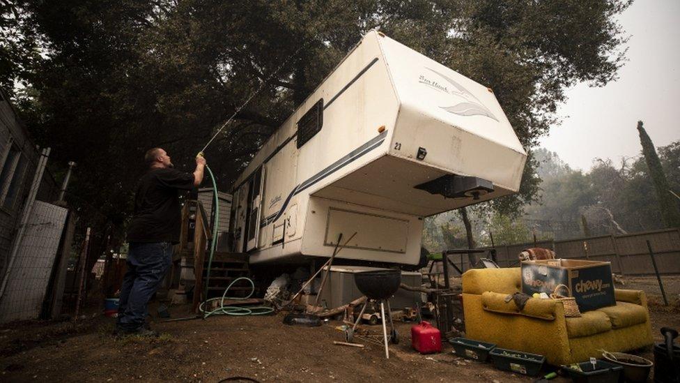 A person hoses his trailer during preparations for evacuation from the Creek Fire, in the Sierra National Forest, 7 September 2020