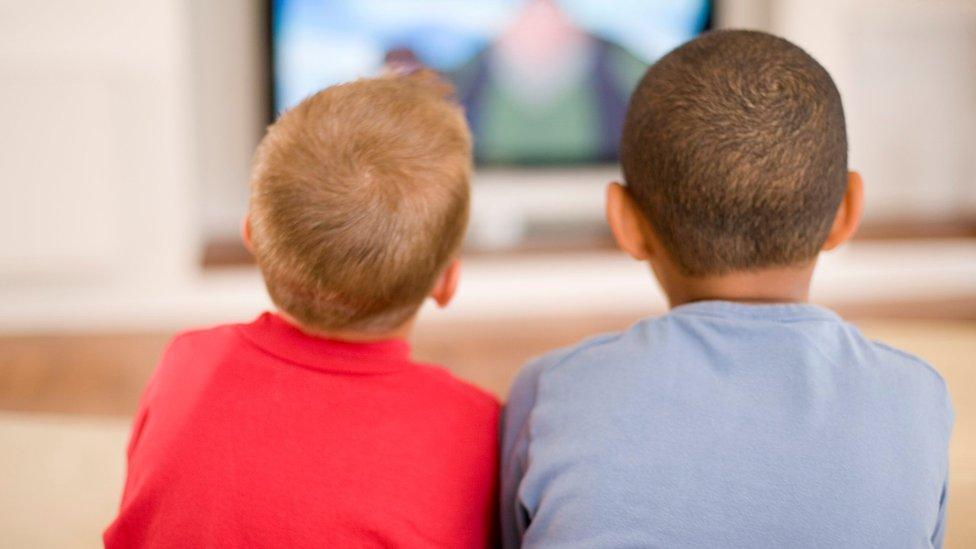 Two boys watching television