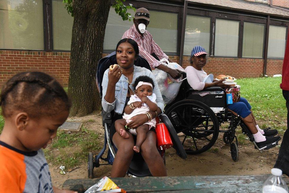 A woman cares for a friend's child during a Feed the City event in Baltimore, Maryland, USA. 26 May 2019.