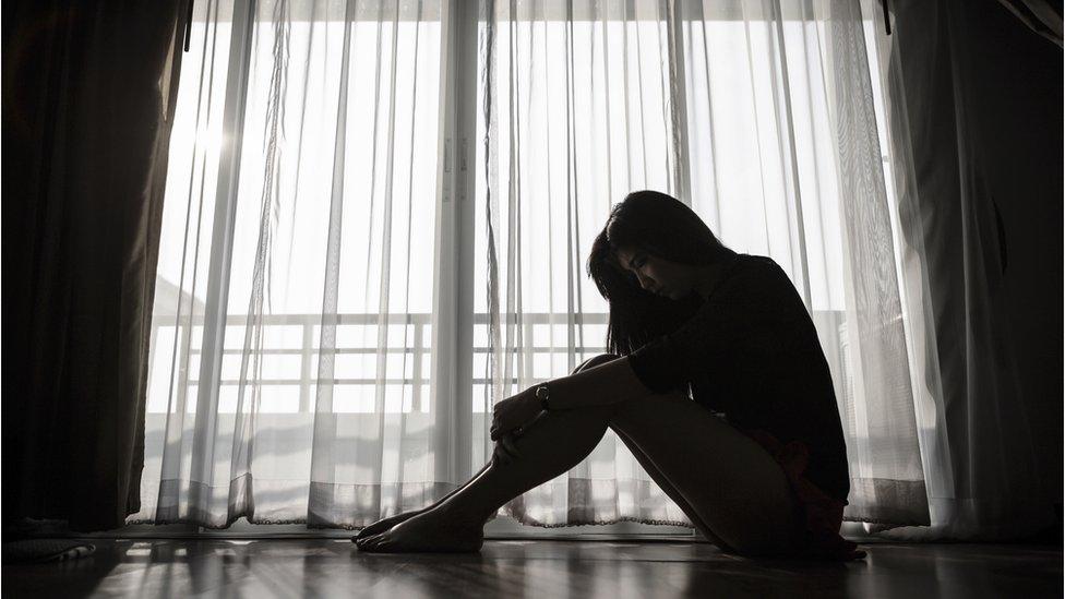 Silhouette of woman at window