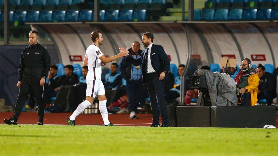 Southgate shakes hands with Harry Kane.