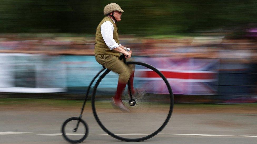 arty shot of man riding on penny farthing