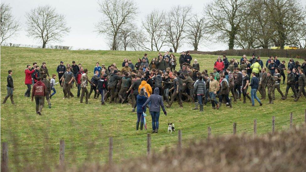 Competitors enter a field with the bottle